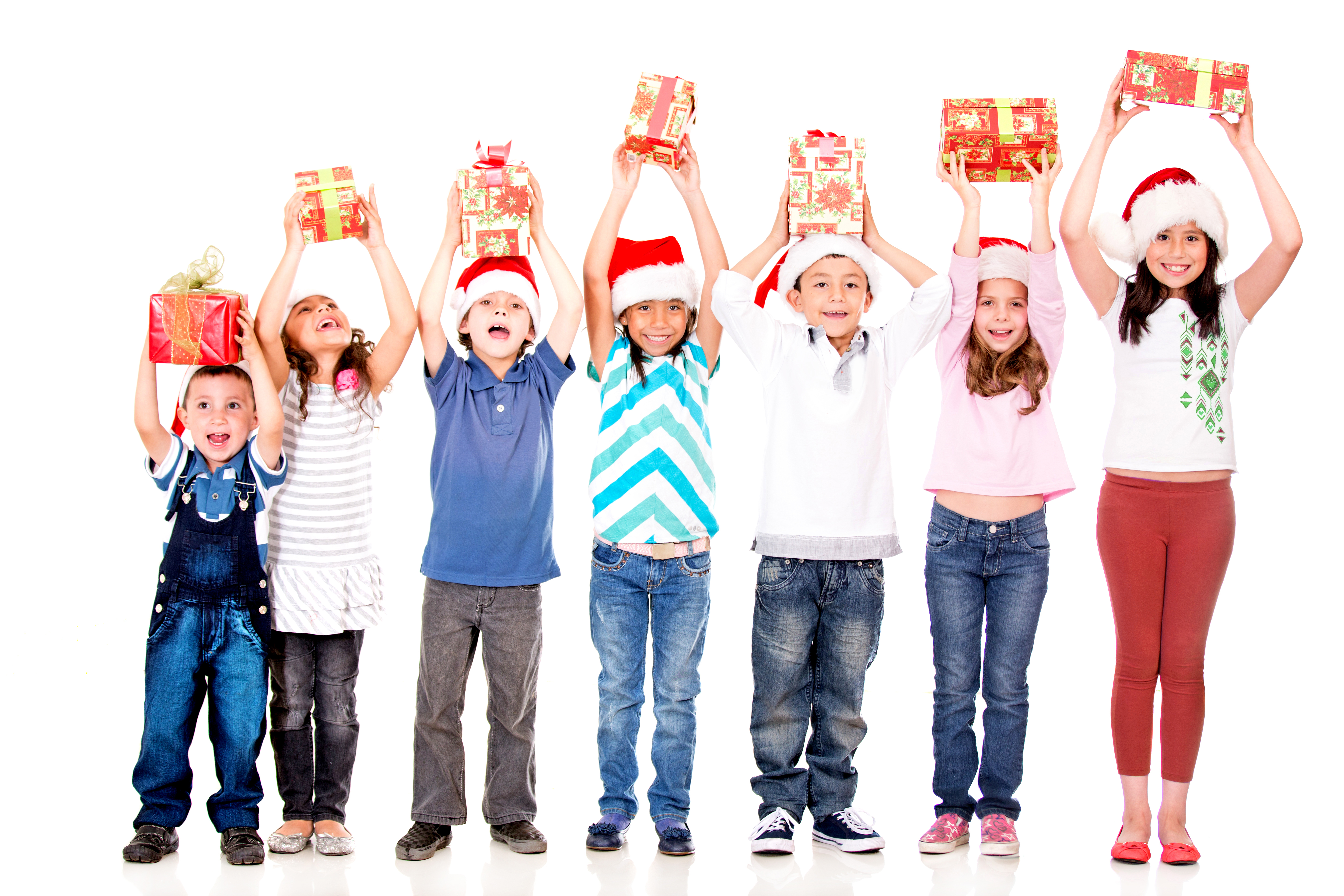 Excited children holding Christmas gifts with arms up - isolated over 