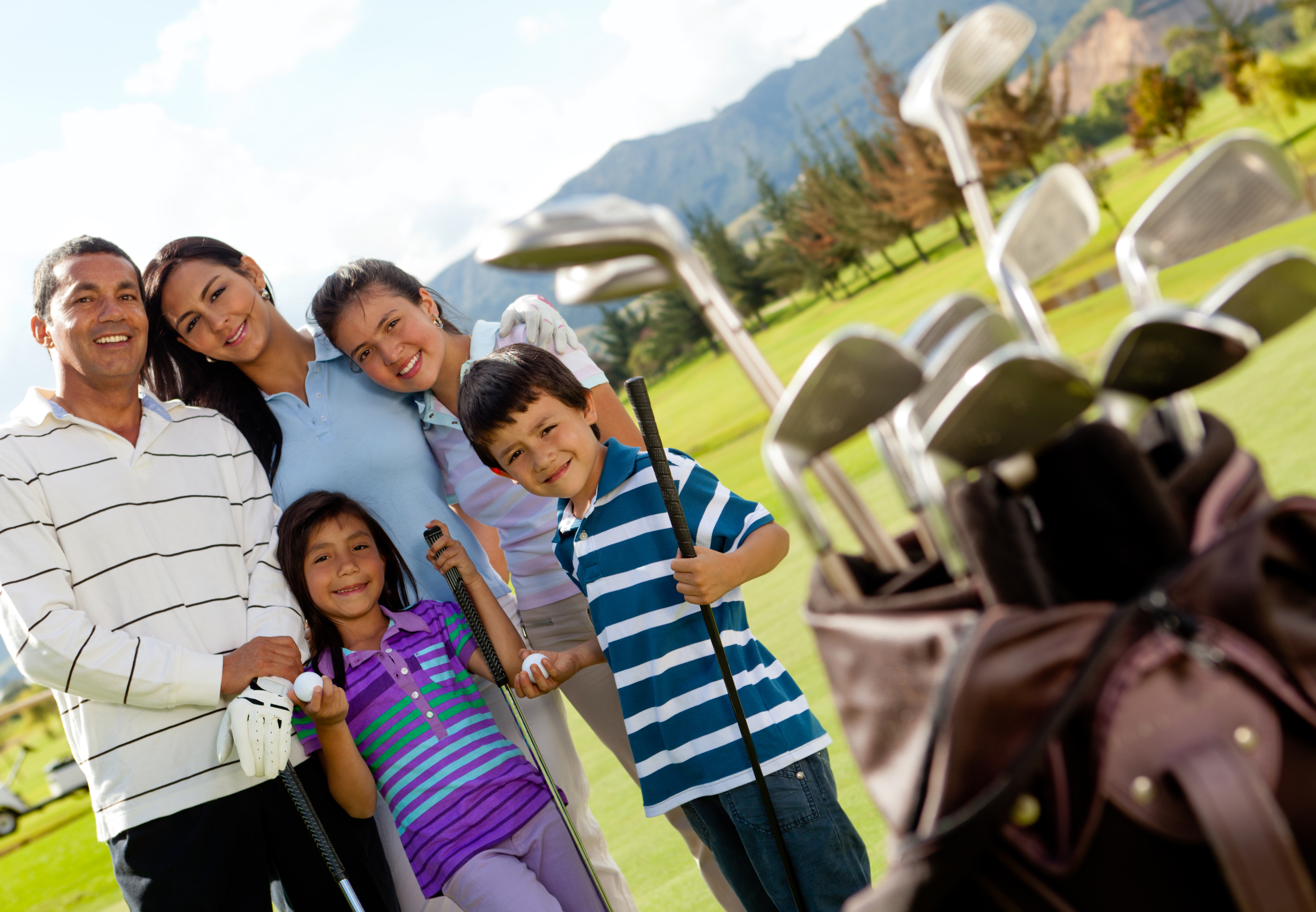 Family of golf players at the course in a beautiful day
