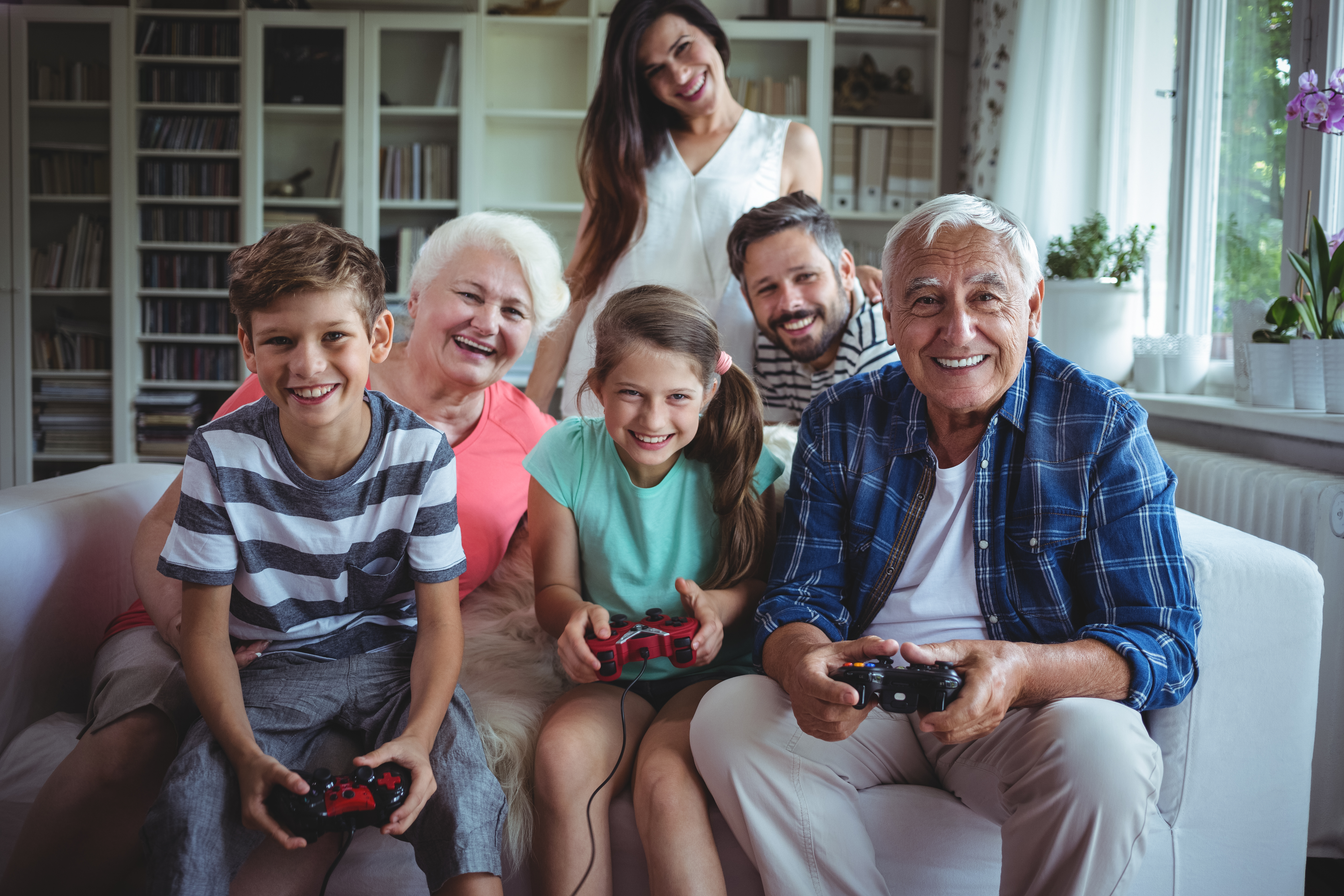 Family watching the kids playing video game at home